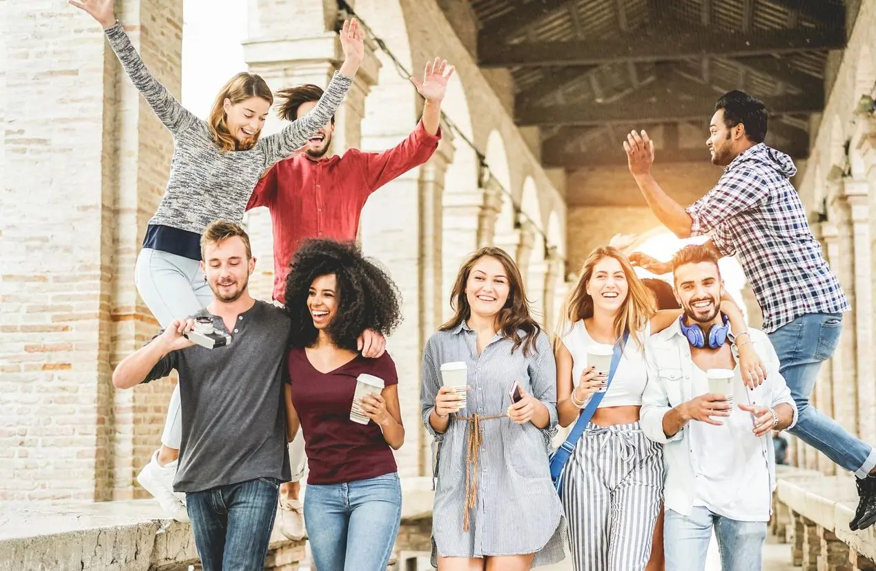 Group of diverse friends celebrating and enjoying drinks together outdoors.