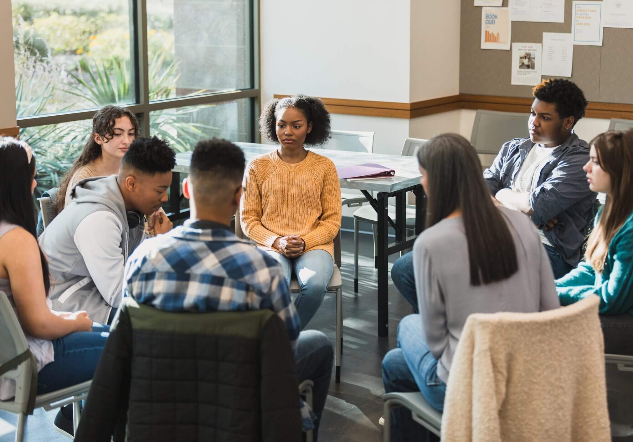 A diverse group in a therapy session sharing and listening.